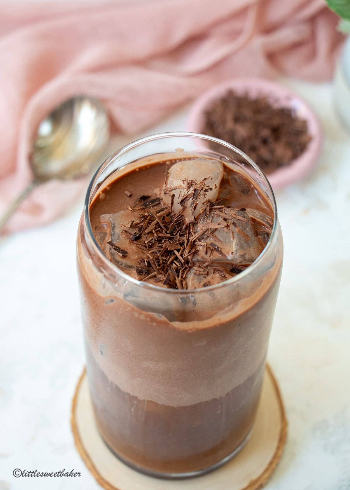 An iced coffee topped with chocolate protein cold foam and chocolate shavings.
