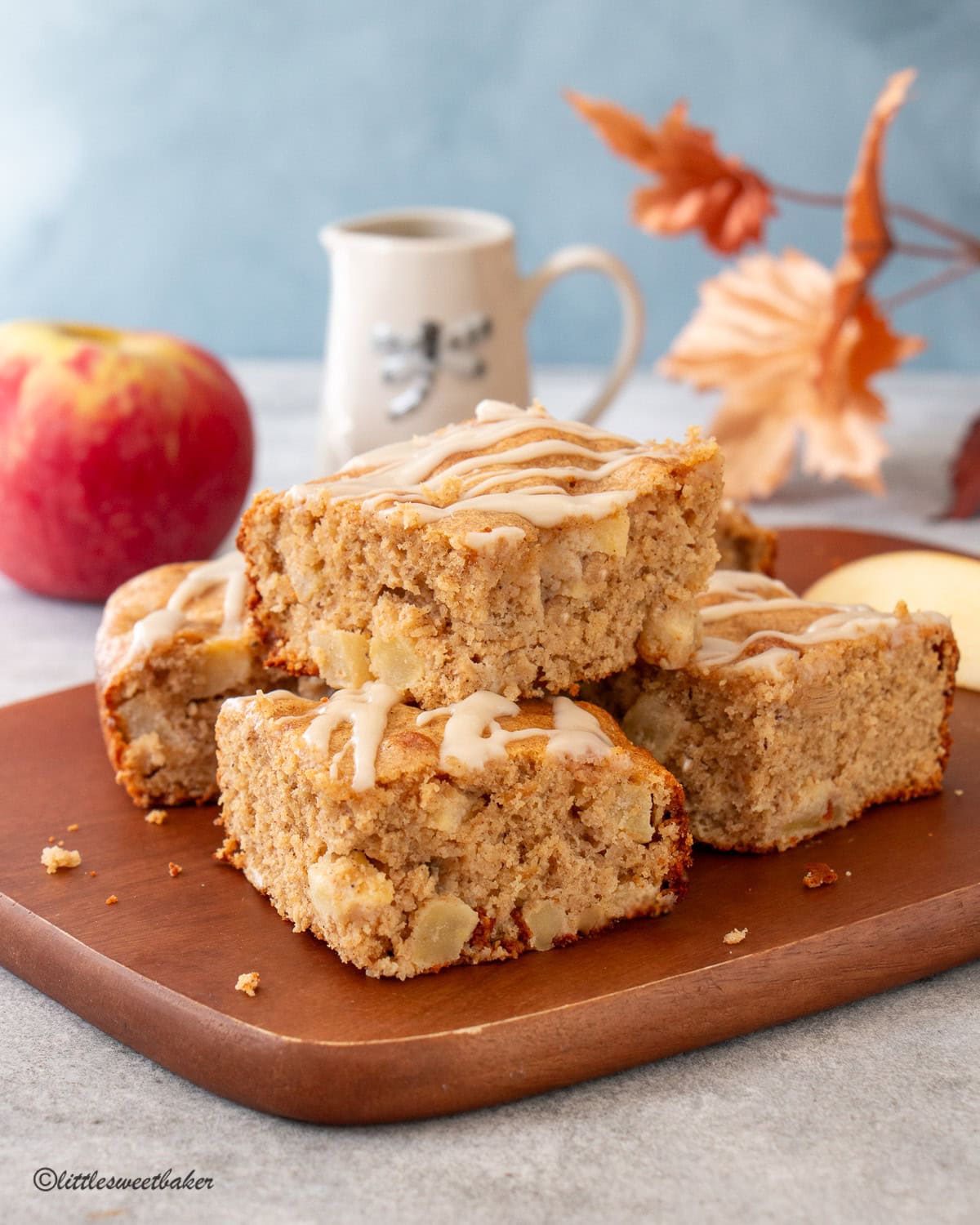Healthy Apple Cake cut into squares in a wooden serving board.