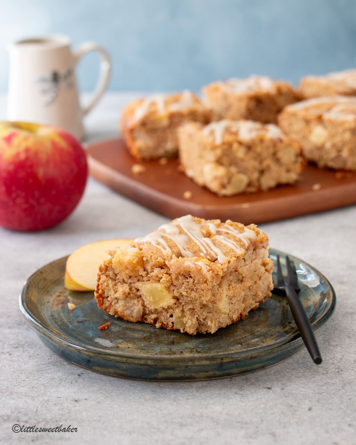 A piece of healthy apple cake on a small pottery dessert plate.