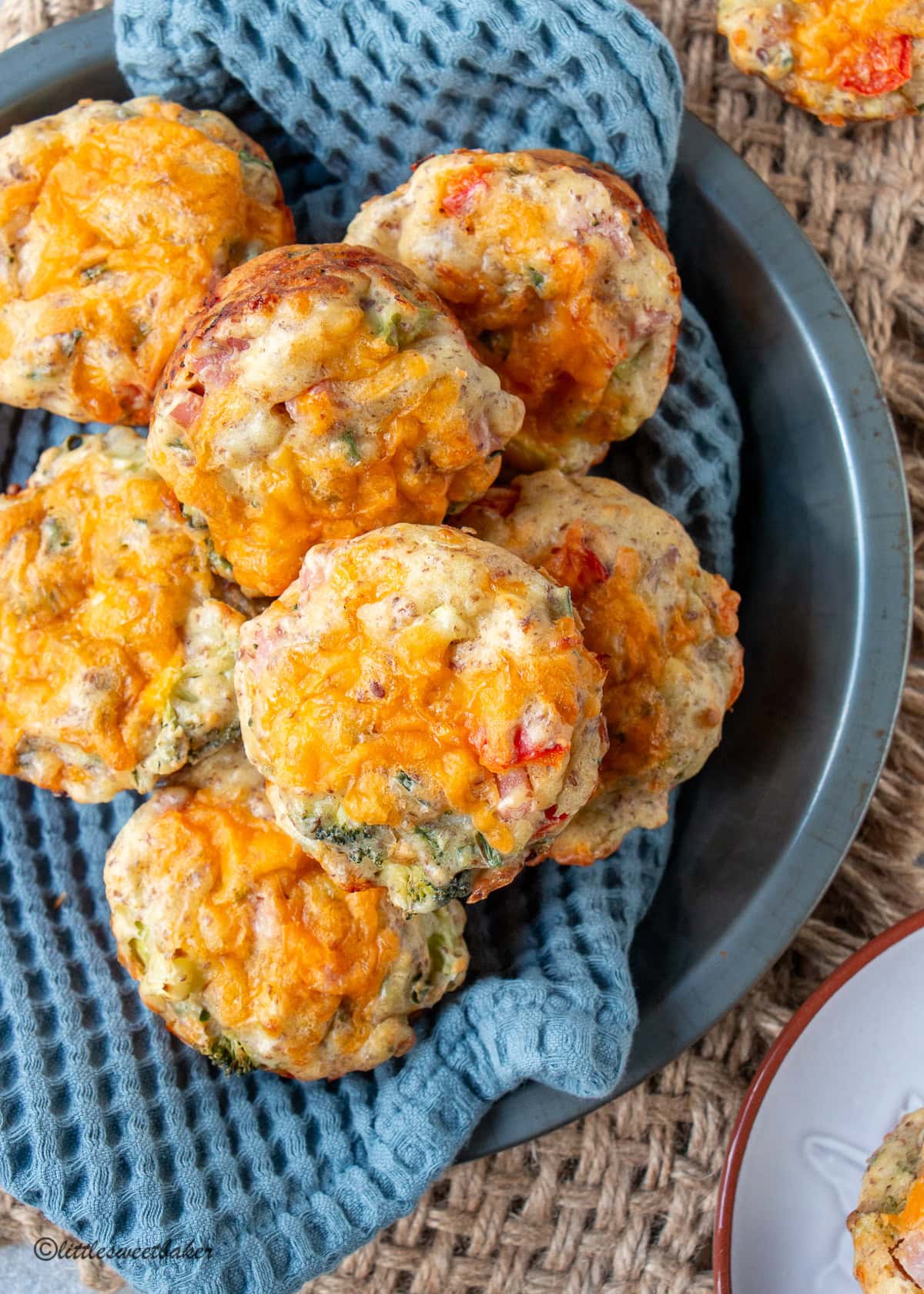 Savory breakfast muffins on a blue wool napkin in a metal pie pan.