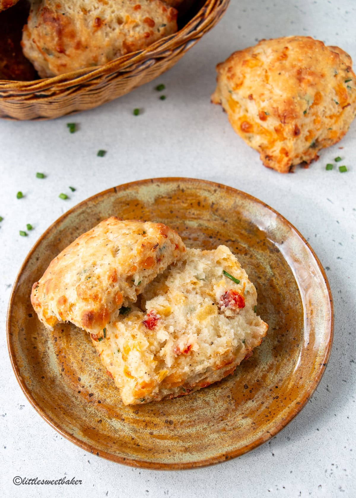 A lobster biscuit broken in half on a brown pottery plate.