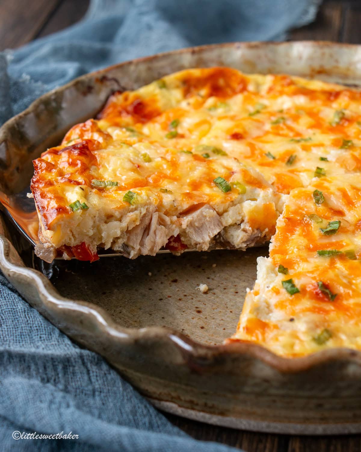 A piece od crustless cottage cheese quiche being lifted out of the dish.