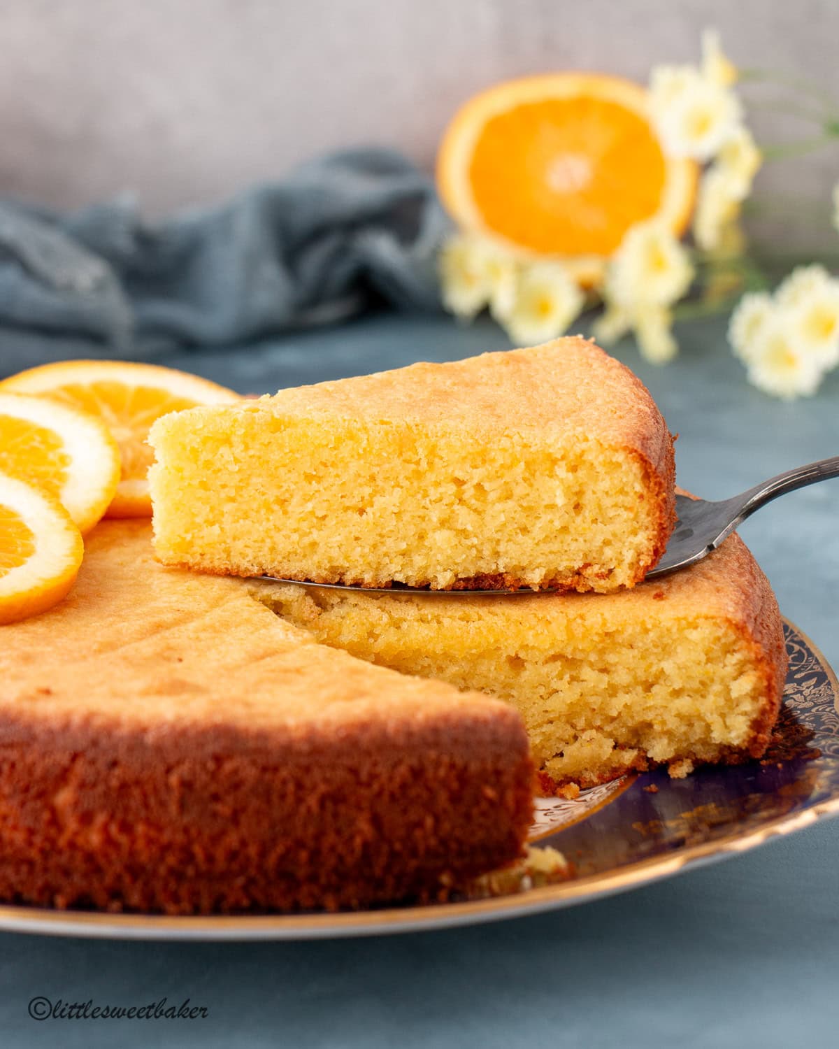 Orange almond flour cake topped with orange slices and one slice cut.