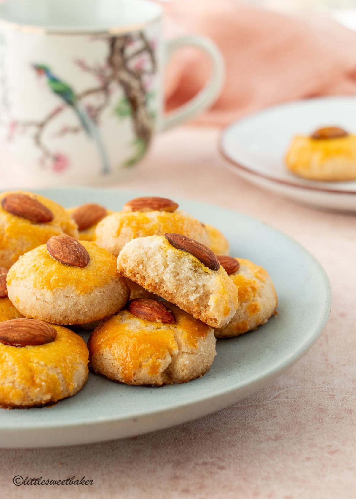 A plate of Chinese Almond Cookies with one broken in half.