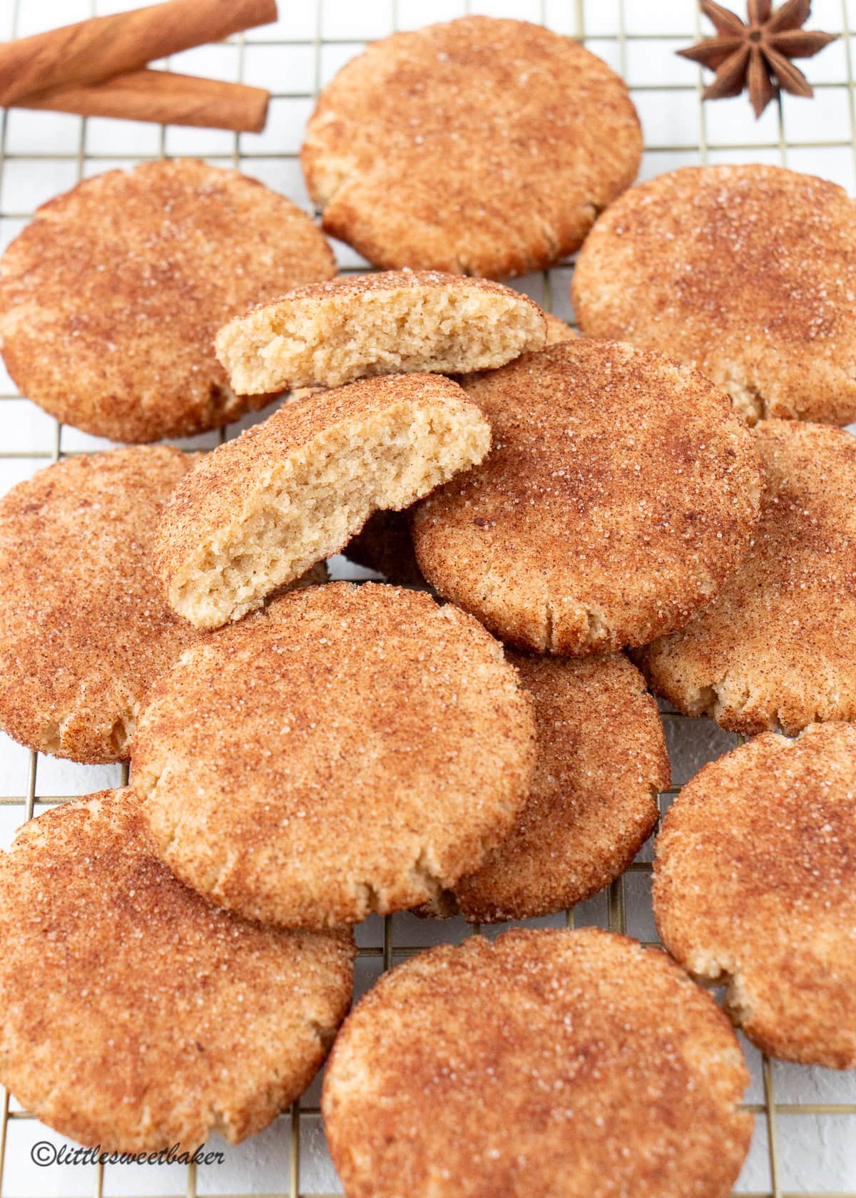 Healthy snickerdoodle cookies scattered on a gold cooling rack.