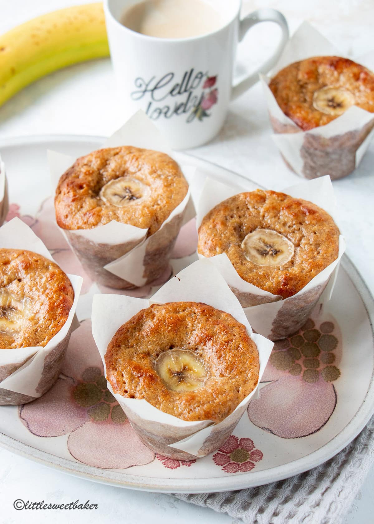 High-protein banana muffins on a floral serving plate.
