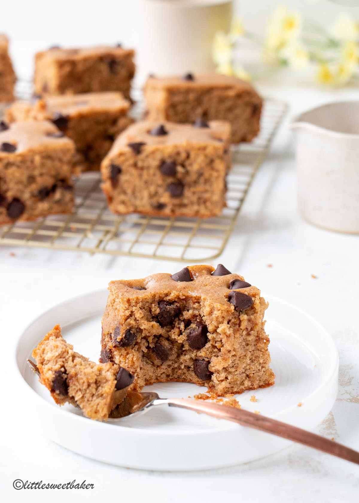  A High-Protein Chocolate Chip Cake Bar on a white plate with a piece on a fork.