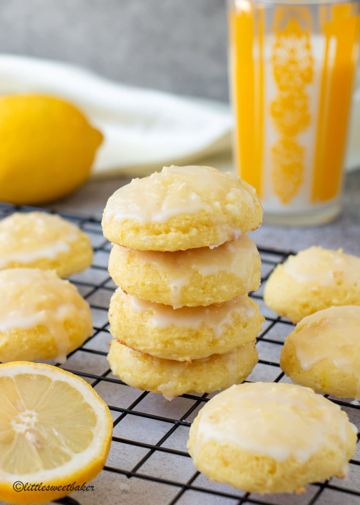 A stack of lemon ricotta cake mix cookies on a cooling rack surrounded by more cookies.