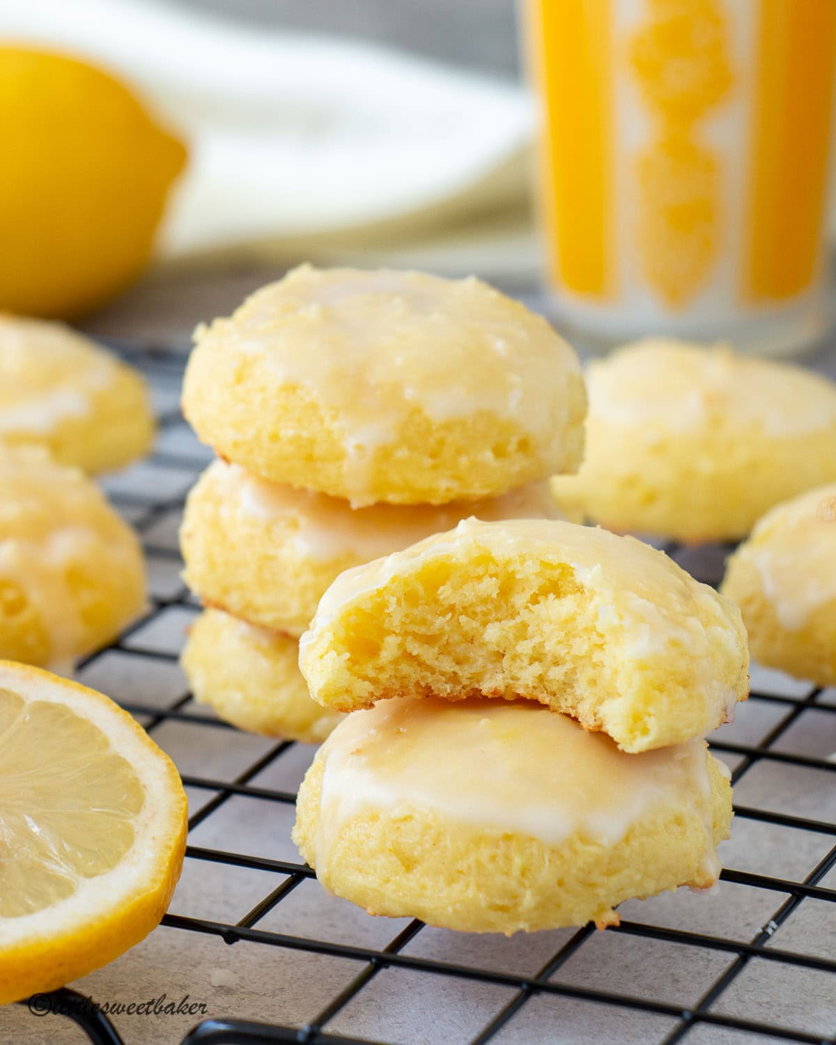 Lemon ricotta cake mix cookies on a cooling rack with one missing a bite.
