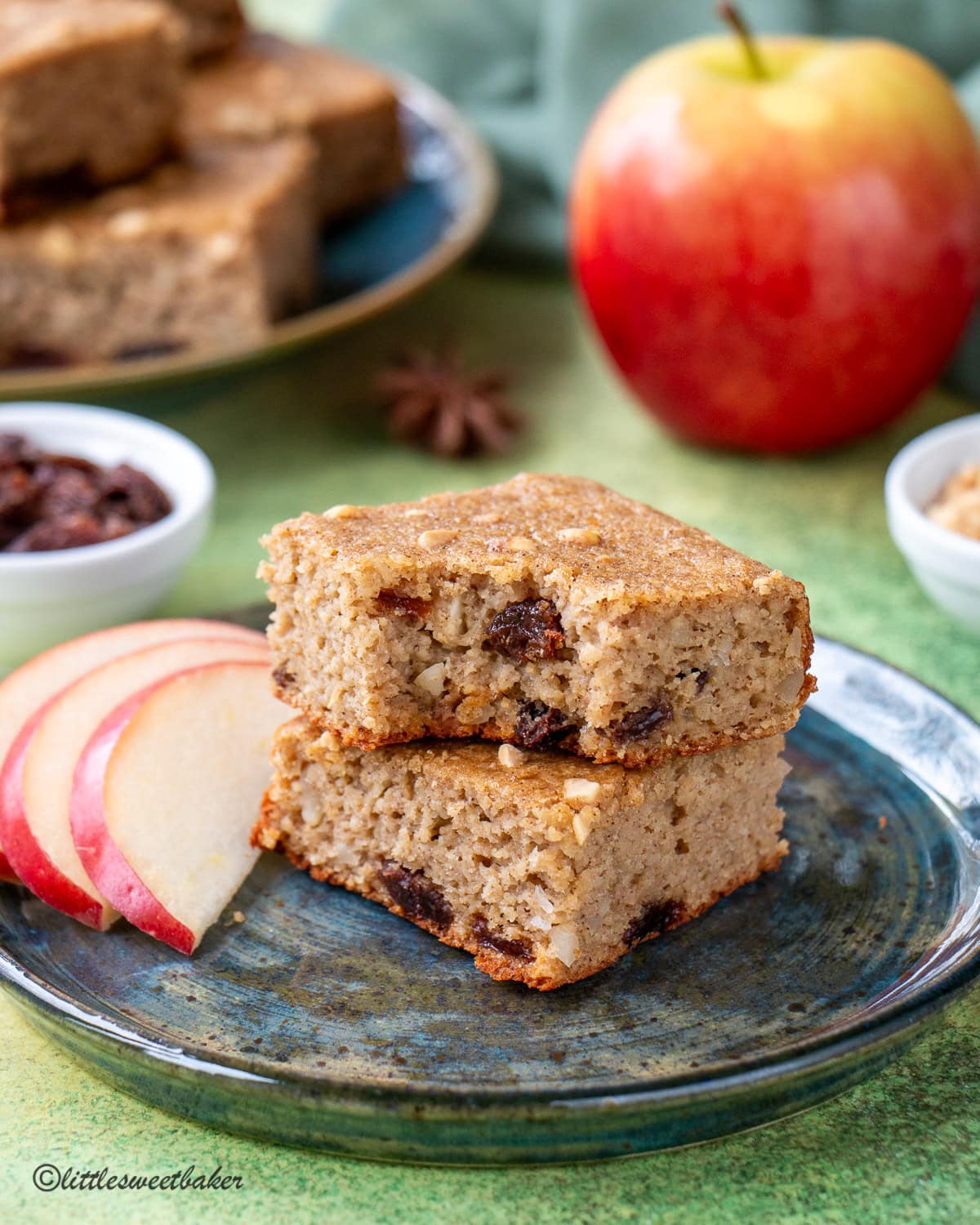 Two slices of healthy applesauce cake on a blue plate with a bite taken out of the top one.