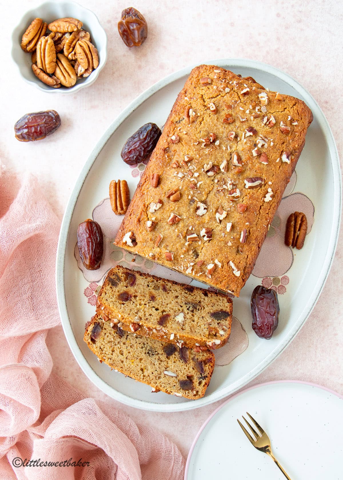 Overhead view of a healthy orange date cake on a floral platter.
