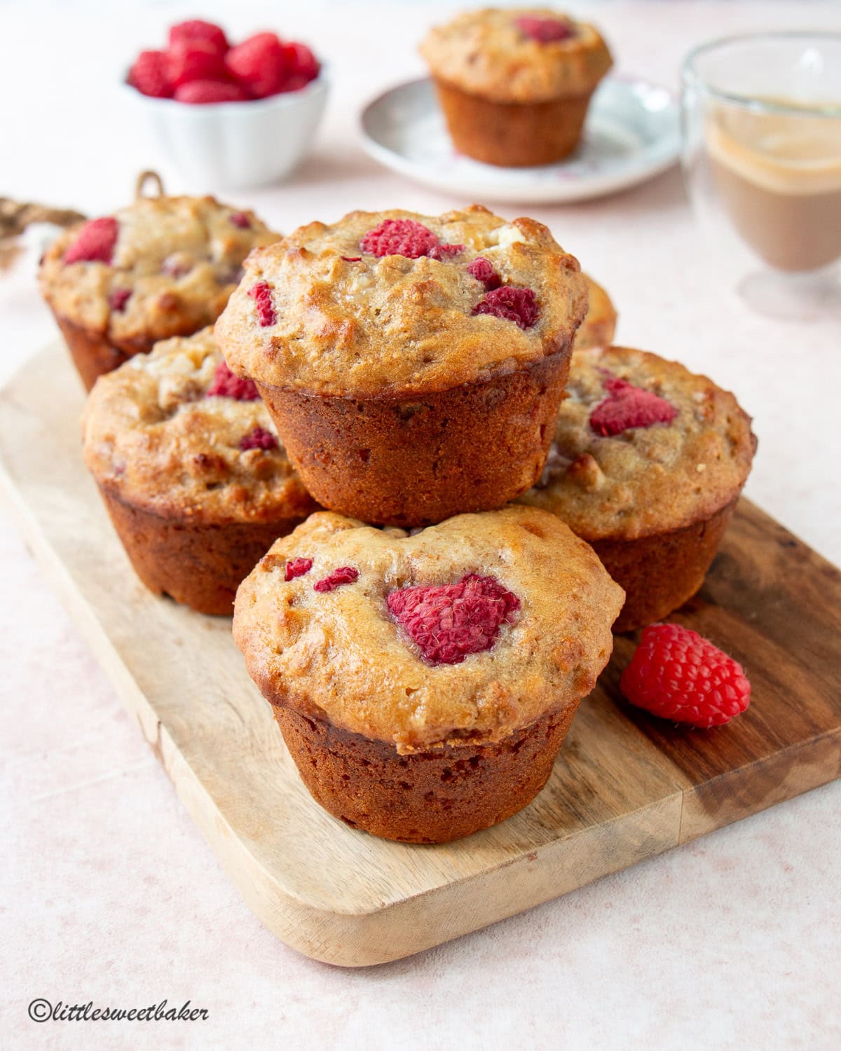 High-fiber raspberry bran muffins on a wooden cutting board.