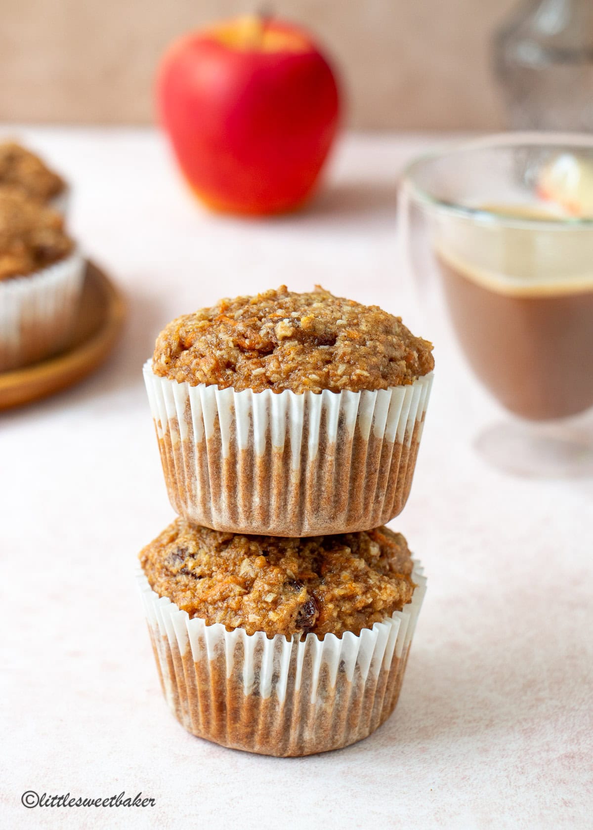Two healthy carrot cake muffins stacked on top of one another.