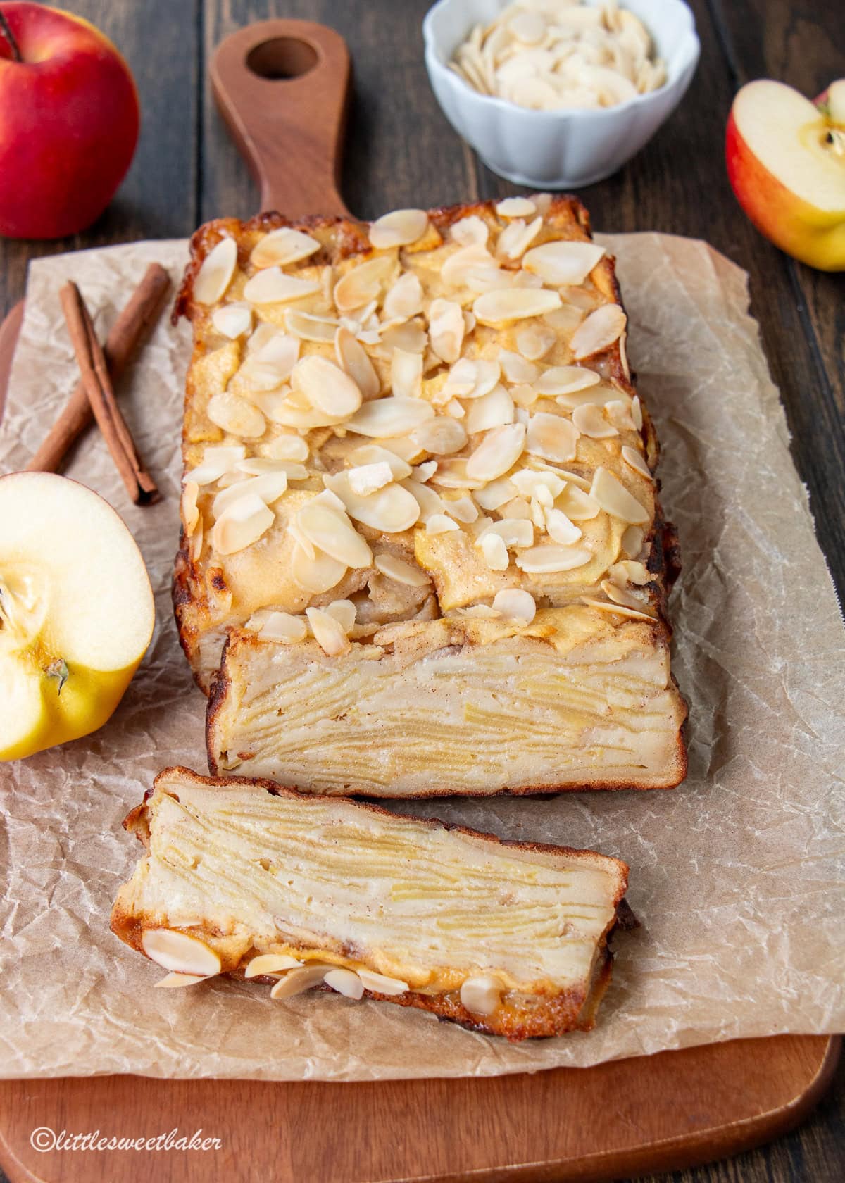 A healthy invisible apple cake on a wooden board with two slices cut.
