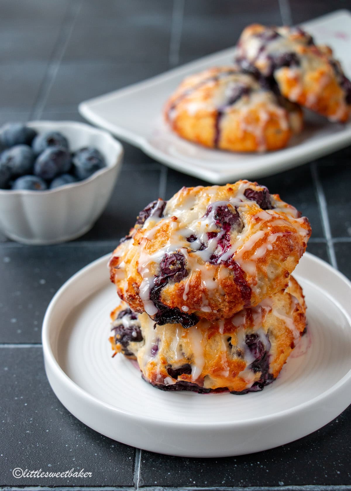 Two healthy baked blueberry fritters on a small white plate.