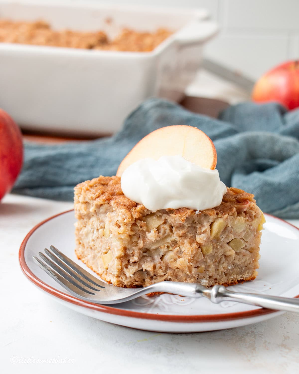 A slice of healthy apple oatmeal cake with a chunk missing.