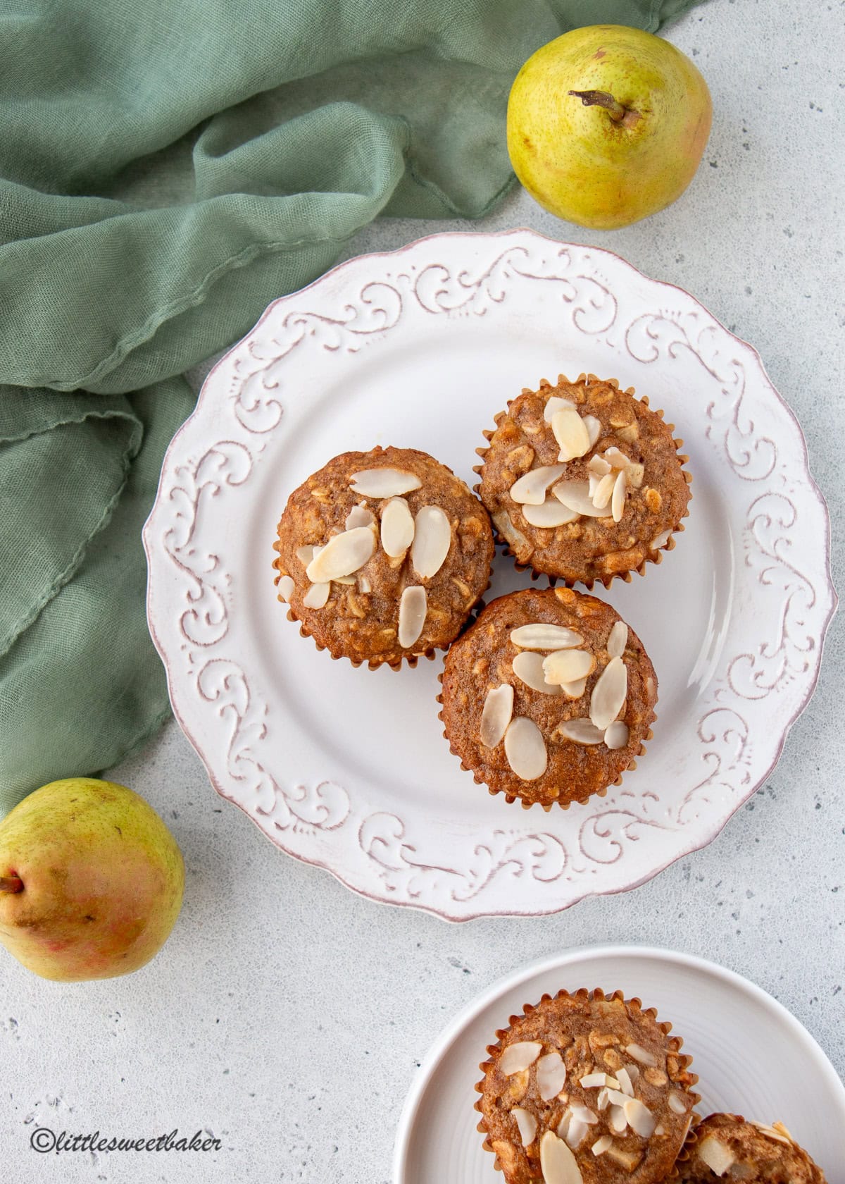 Three healthy pear muffins on a white plate.